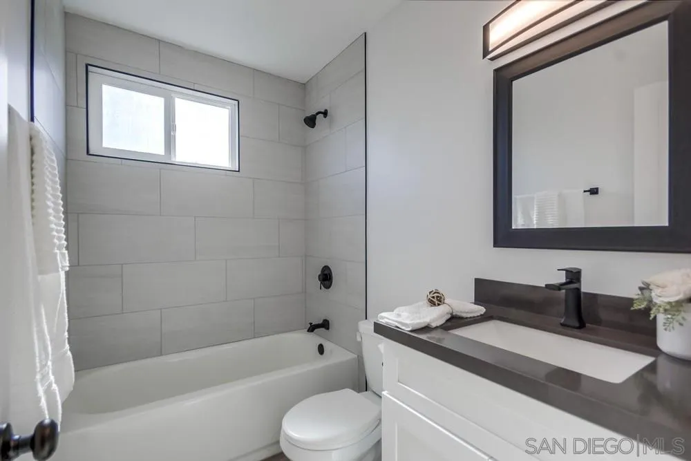 10021 Allenwood Way Santee, CA 92071 - Photo 24 of 30 a bathroom with a granite countertop sink toilet mirror and bathtub