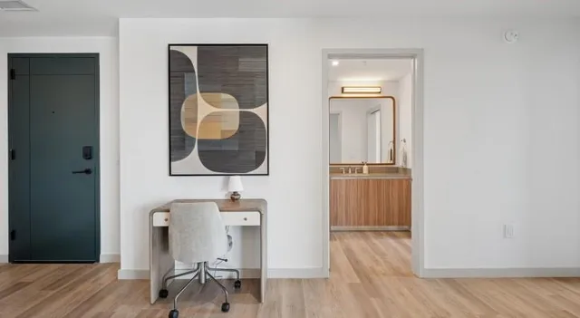 a hallway with wooden floor table and chairs