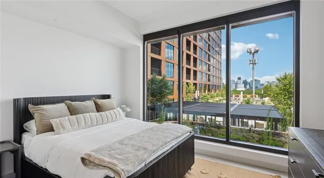 a bedroom with a bed and a large window with outer view