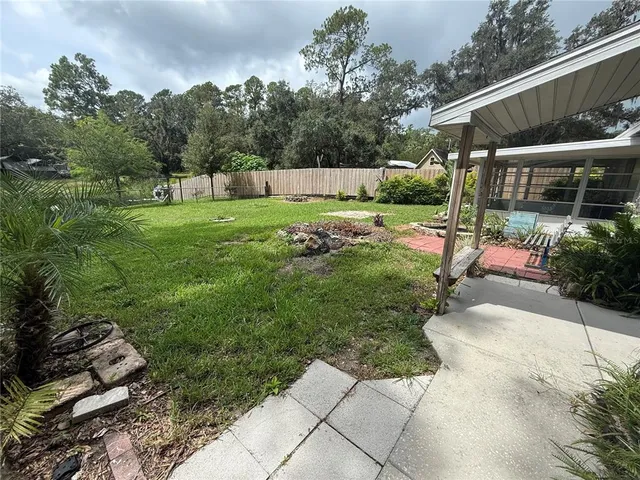 a view of a back yard with flower plants and wooden fence