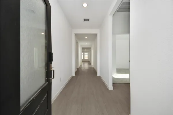a view of a hallway with wooden floor