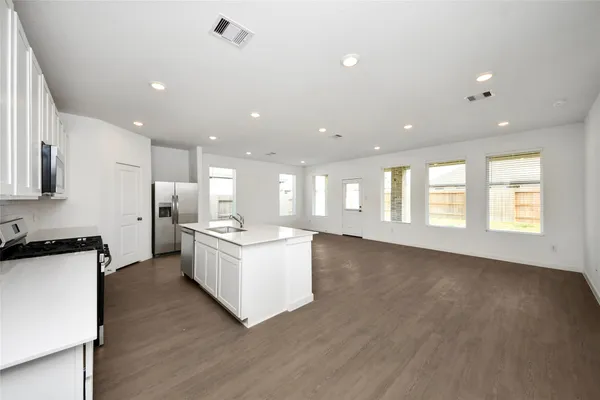 a kitchen with kitchen island a sink stainless steel appliances and cabinets