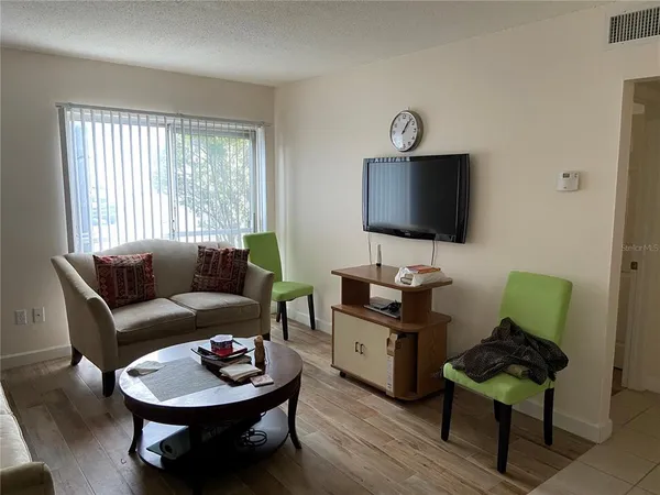 a living room with furniture a rug and a flat screen tv