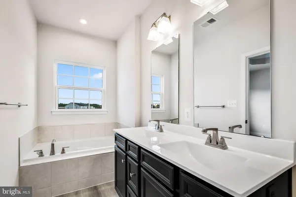 a bathroom with a sink a toilet a mirror and shower