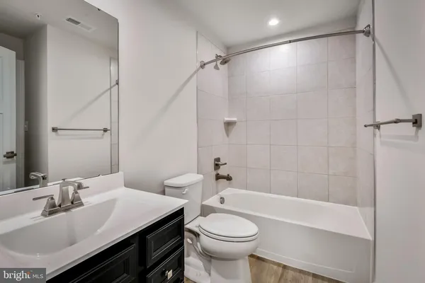 a bathroom with a sink toilet vanity and shower