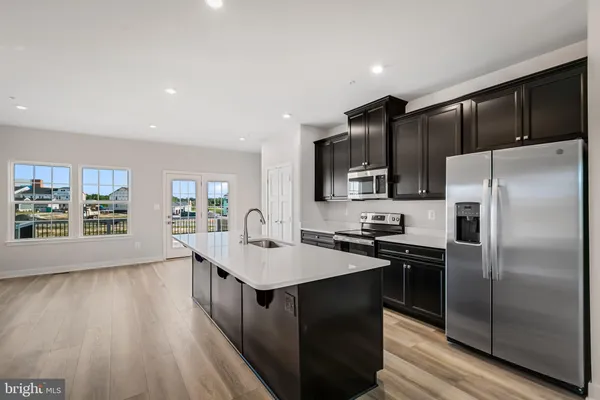 a kitchen with kitchen island white cabinets and stainless steel appliances