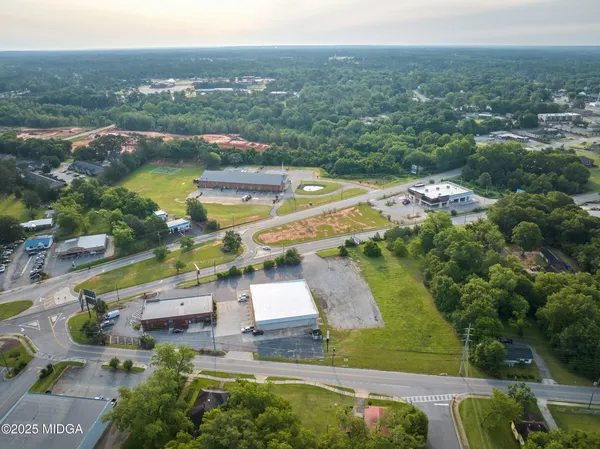 an aerial view of residential houses with outdoor space and ocean view