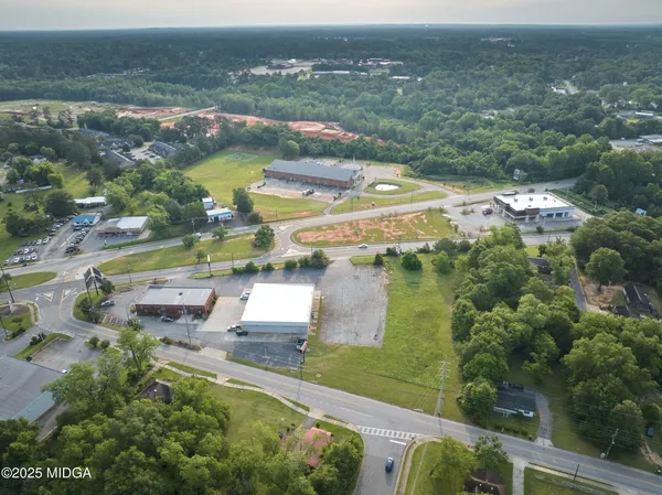 an aerial view of residential houses with outdoor space and trees
