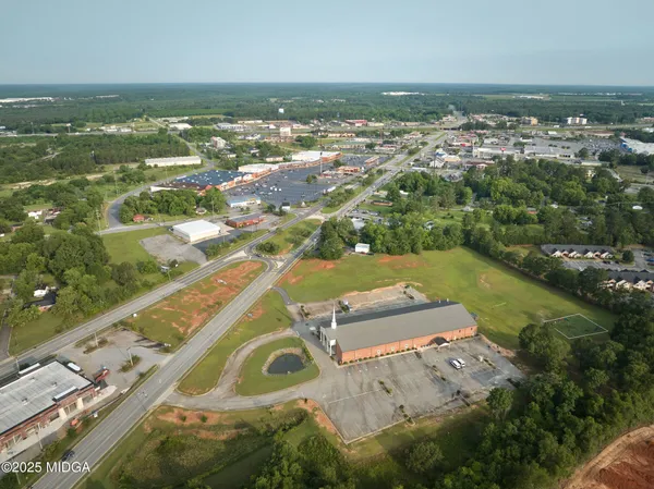 an aerial view of residential houses with outdoor space and trees