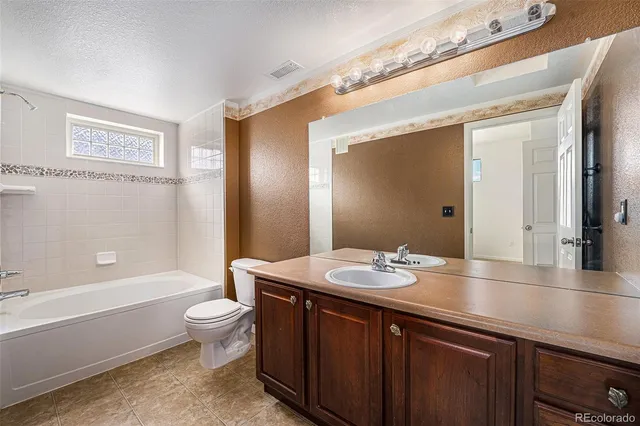 a bathroom with a granite countertop sink and a bathtub