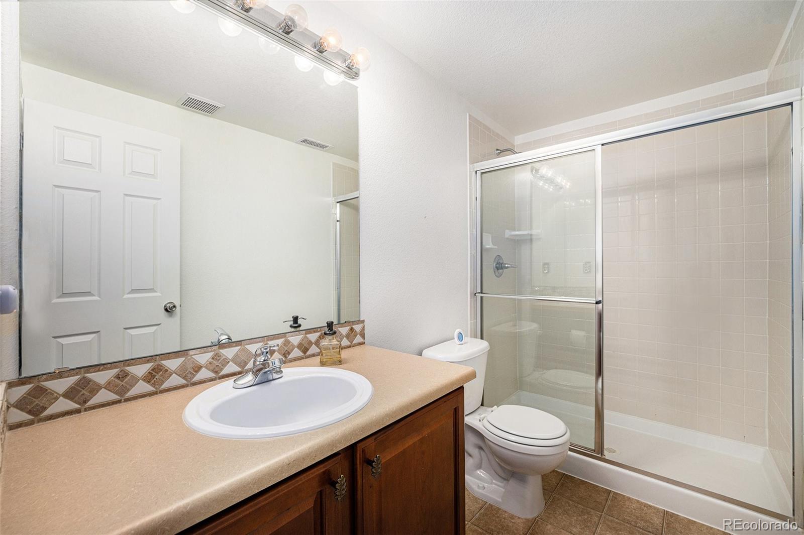 5800 Tower Road, Unit 505 Denver, CO 80249 - Photo 12 of 24 a bathroom with a sink and a mirror