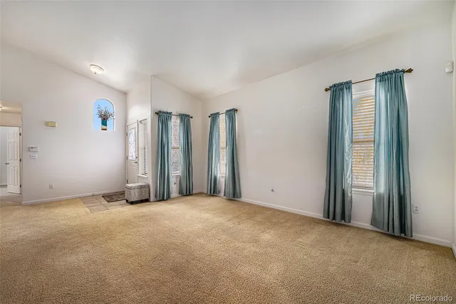 an empty room with closet and windows