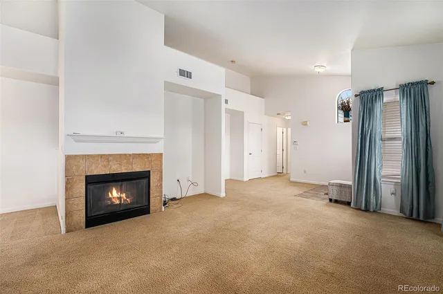 a view of an empty room with fire place and a fireplace