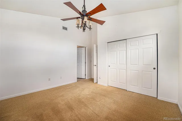 an empty room with chandelier fan
