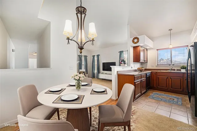 a kitchen with stainless steel appliances a table and chairs in it
