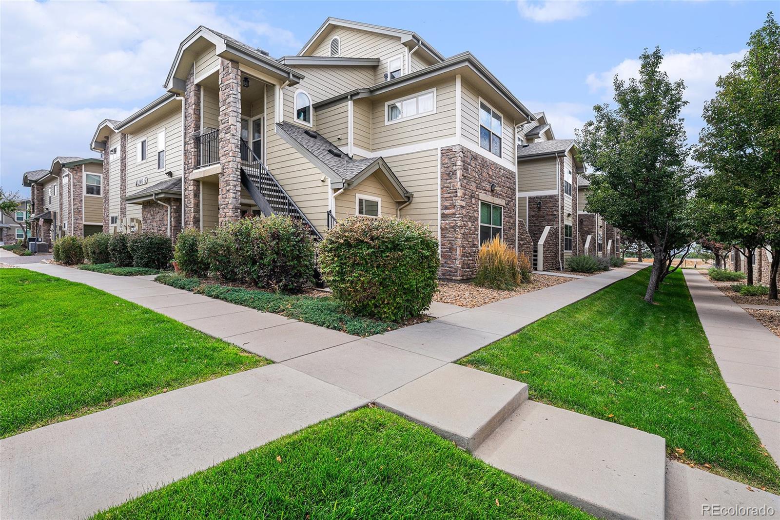 5800 Tower Road, Unit 505 Denver, CO 80249 - Photo 4 of 24 a front view of a house with a yard and potted plants