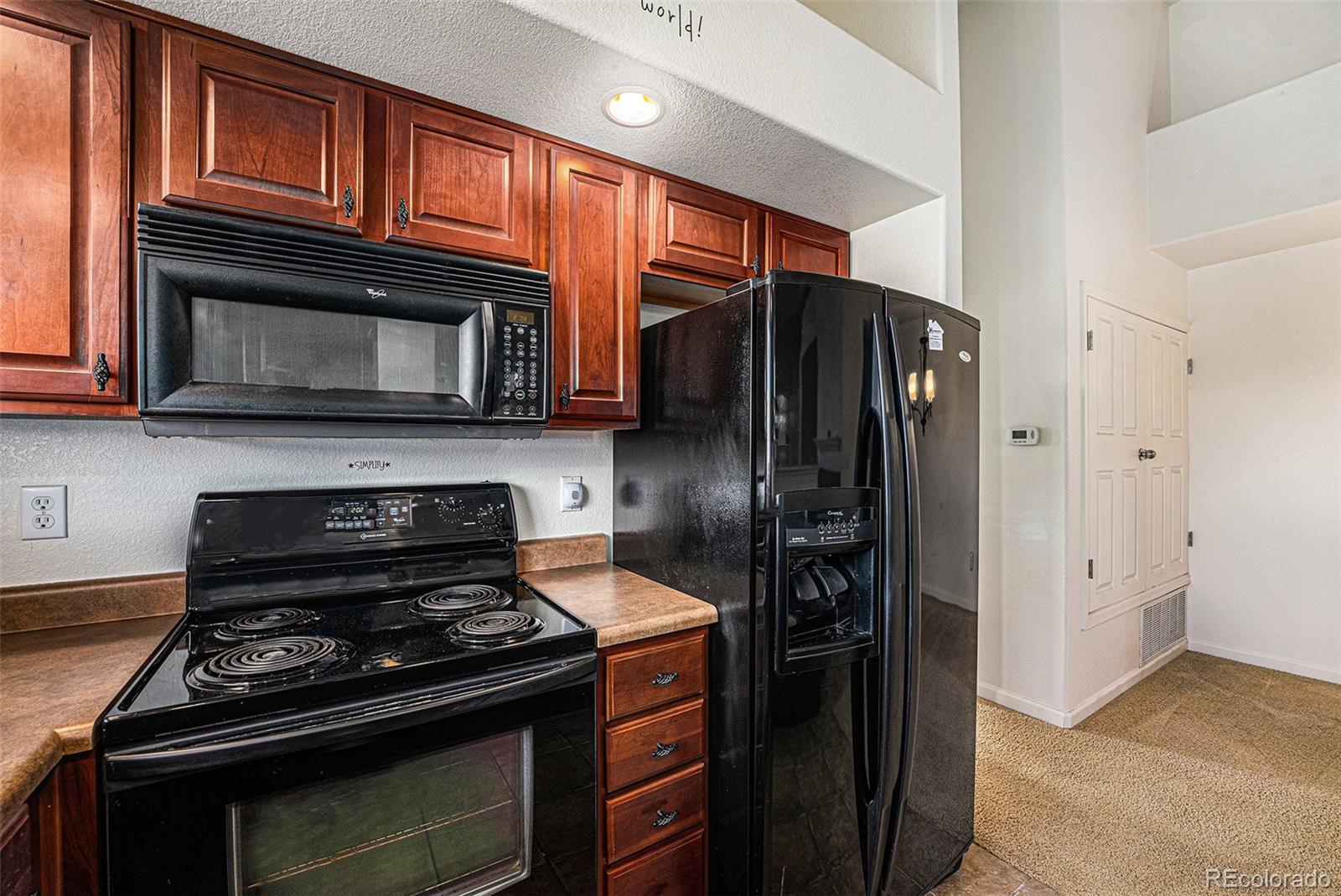 5800 Tower Road, Unit 505 Denver, CO 80249 - Photo 7 of 24 a kitchen with stainless steel appliances and granite countertop wooden cabinets