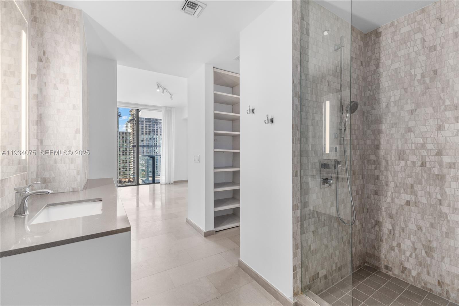 68 Southeast 6th Street, Unit 2006 Miami, FL 33131 - Photo 19 of 49 a bathroom with a sink shower and a mirror