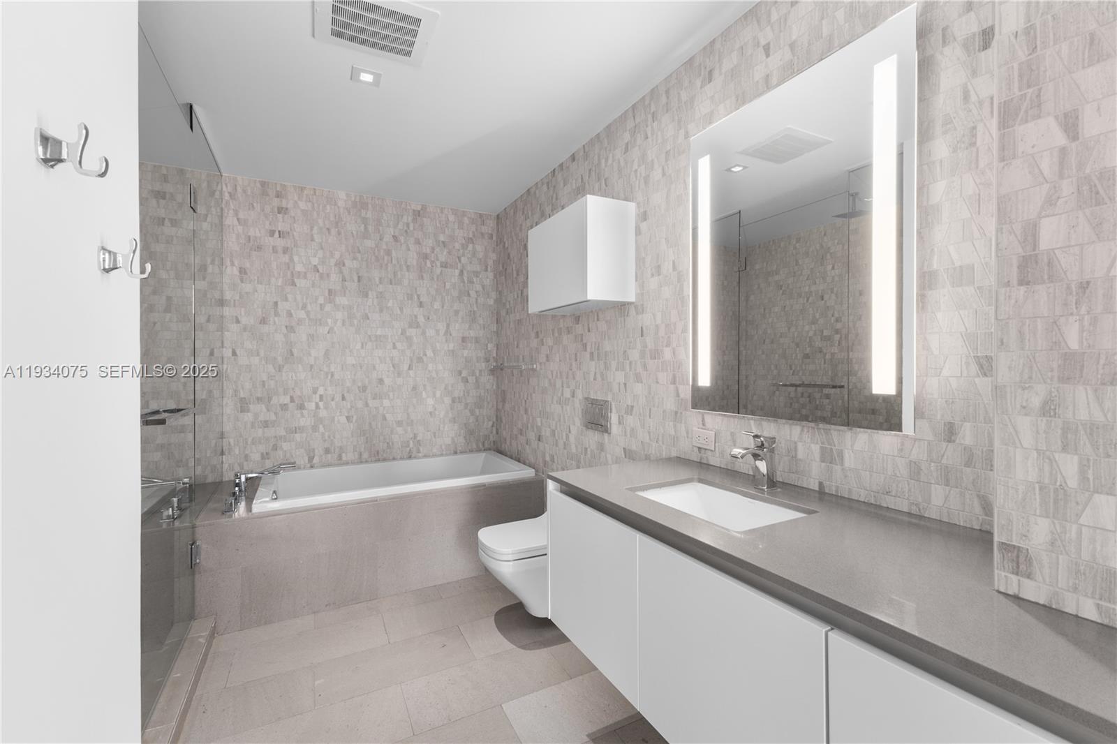 68 Southeast 6th Street, Unit 2006 Miami, FL 33131 - Photo 21 of 49 a bathroom with a bathtub a sink and a shower