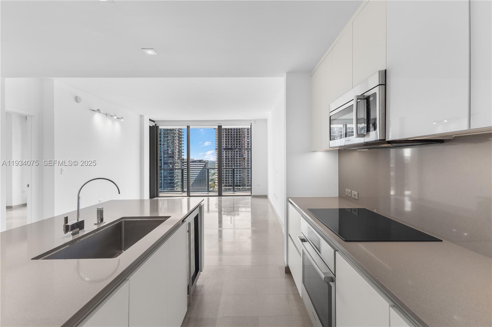68 Southeast 6th Street, Unit 2006 Miami, FL 33131 - Photo 6 of 49 a kitchen with a sink and a refrigerator