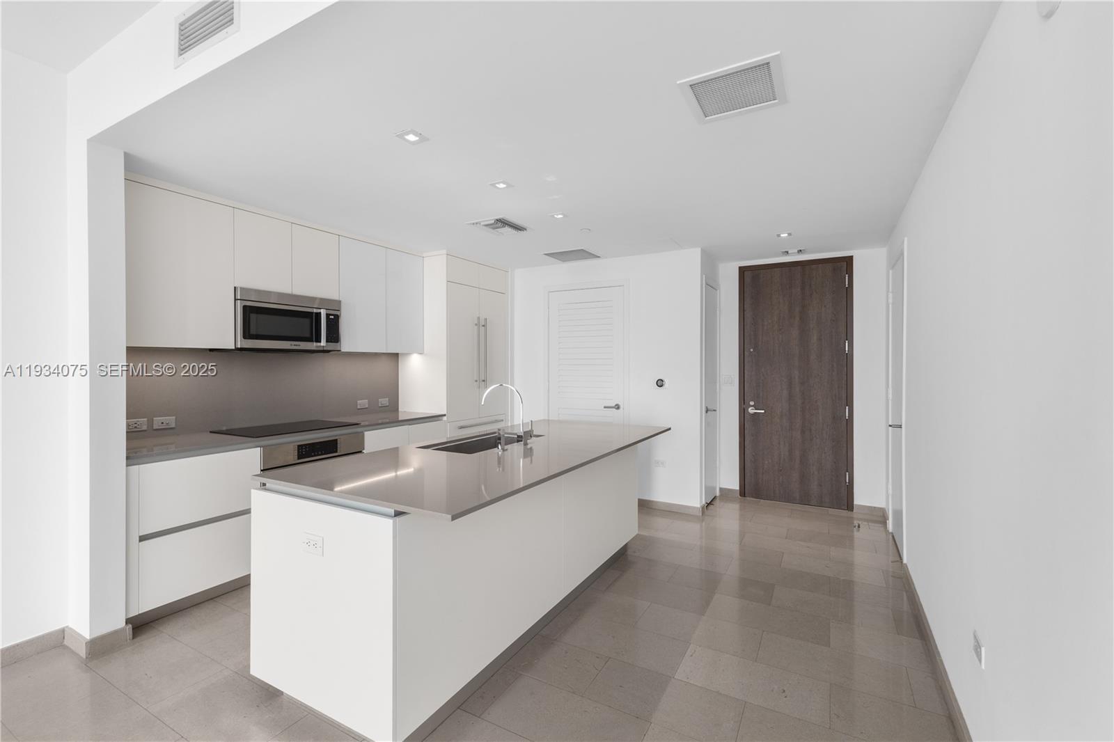 68 Southeast 6th Street, Unit 2006 Miami, FL 33131 - Photo 9 of 49 a kitchen with granite countertop a sink and a stove top oven