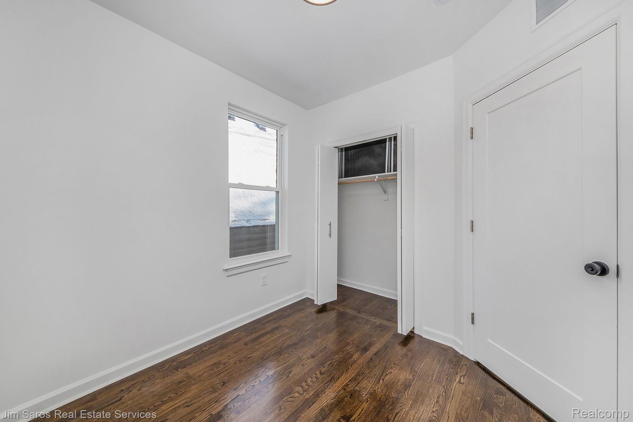 249 Custer Street Detroit, MI 48202 - Photo 11 of 22 Room featuring wood-finish flooring, white walls, and a single window with white trim