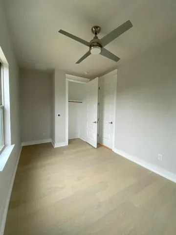 an empty room with a ceiling fan and a window