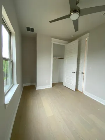 an empty room with windows and closet