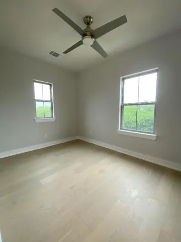 an empty room with a window and a fan