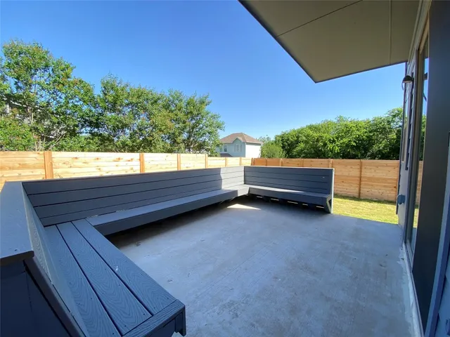 a backyard of a house with wooden floor and outdoor seating