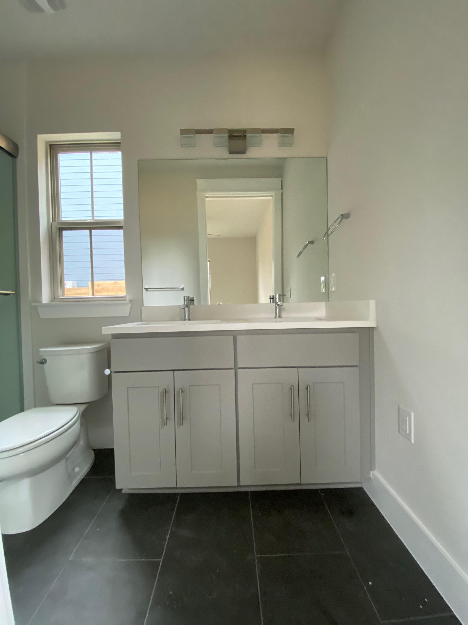 6920 Bethune Avenue, Unit 3 Austin, TX 78752 - Photo 28 of 32 Bathroom with double vanity, a shower with shower door, and dark tile patterned floors