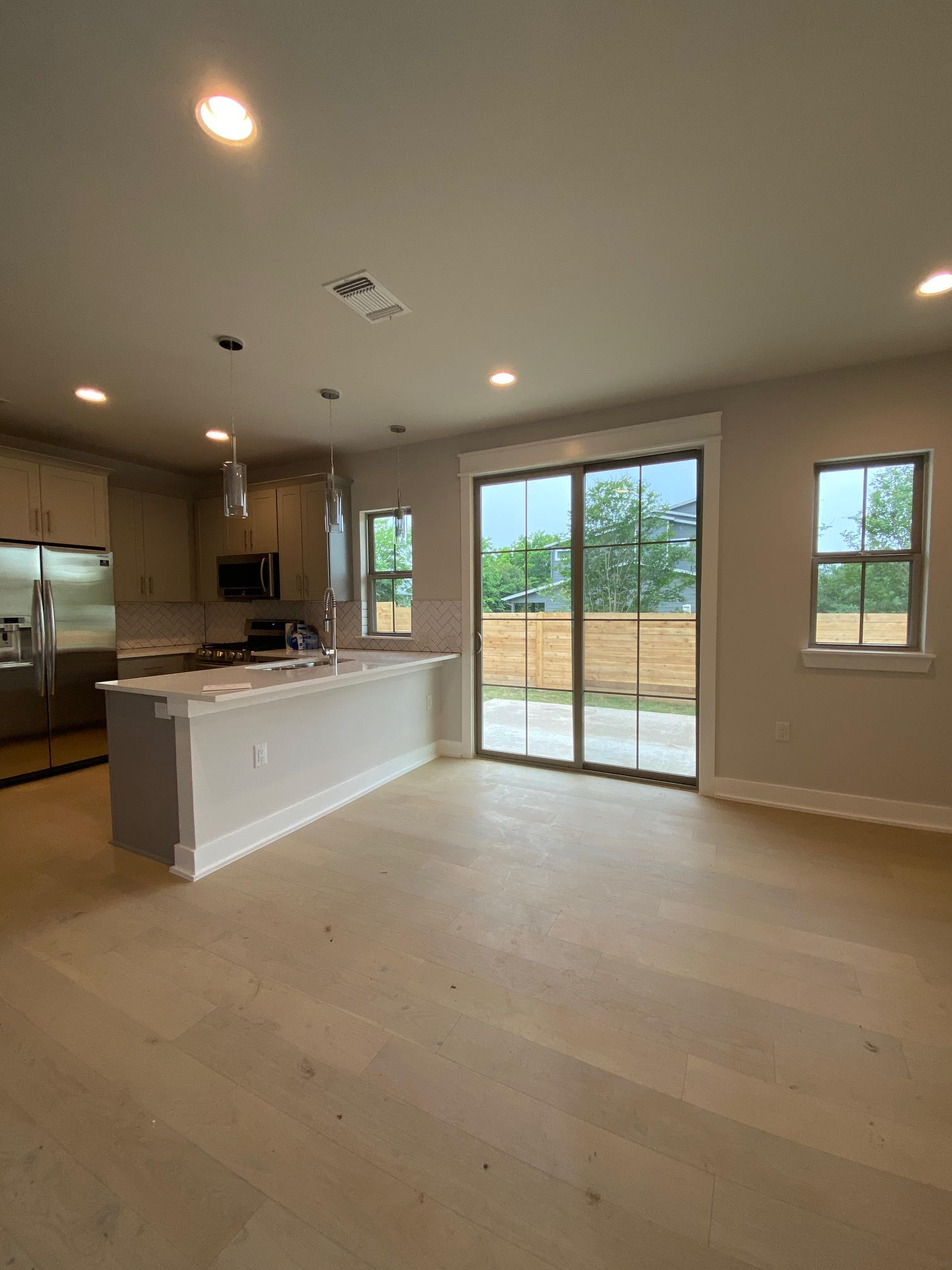 6920 Bethune Avenue, Unit 3 Austin, TX 78752 - Photo 32 of 32 Kitchen featuring appliances with stainless steel finishes, hanging light fixtures, open floor plan, recessed lighting, and light wood-style flooring