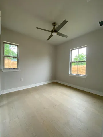 an empty room with a window and a ceiling fan