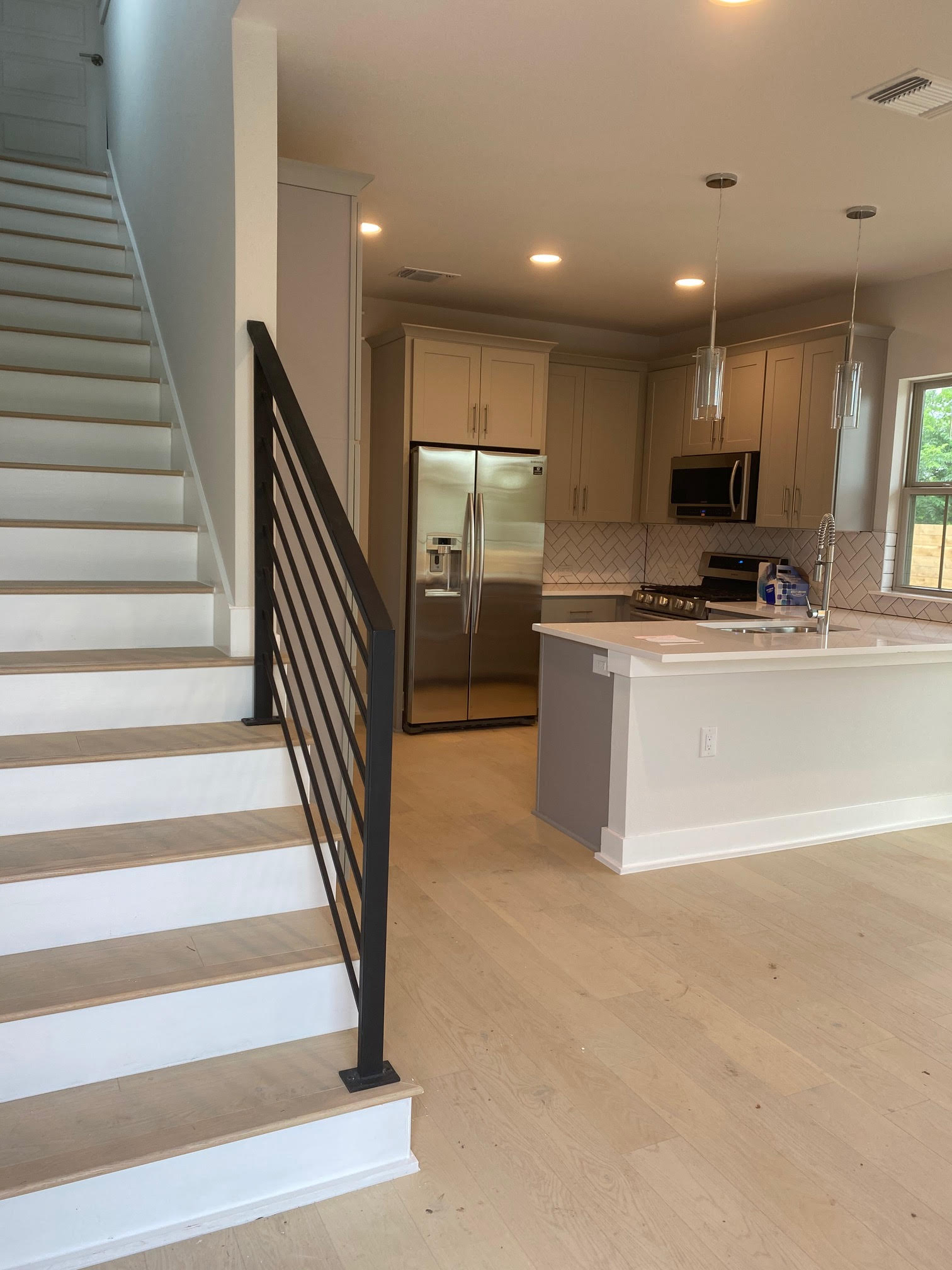6920 Bethune Avenue, Unit 3 Austin, TX 78752 - Photo 5 of 32 Kitchen featuring appliances with stainless steel finishes, pendant lighting, gray cabinets, a peninsula, and light wood-style flooring