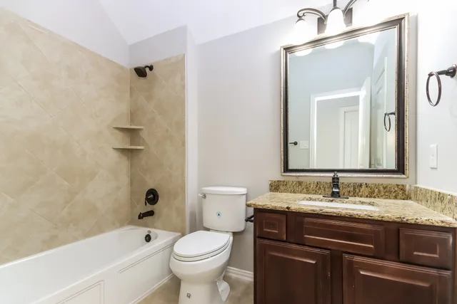 a bathroom with a granite countertop sink toilet and shower