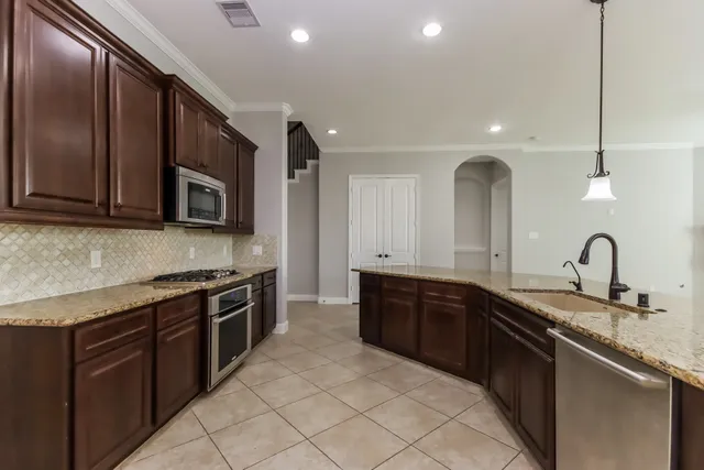 a large kitchen with stainless steel appliances granite countertop a sink and stove top oven