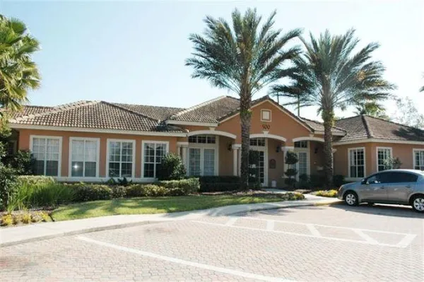 a front view of a house with a garden and palm tree