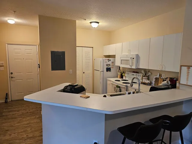 a kitchen with a sink and chairs