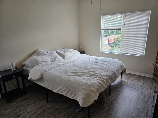 a large bed sitting in a bedroom next to a window