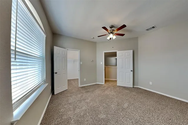 a view of an empty room with a ceiling fan