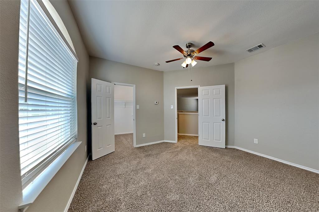 1202 Dove Brook Drive Allen, TX 75002 - Photo 12 of 23 Unfurnished bedroom with a walk in closet, carpet, and a ceiling fan