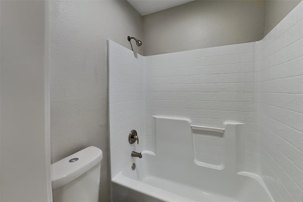1202 Dove Brook Drive Allen, TX 75002 - Photo 19 of 23 Full bathroom with a textured wall and washtub / shower combination