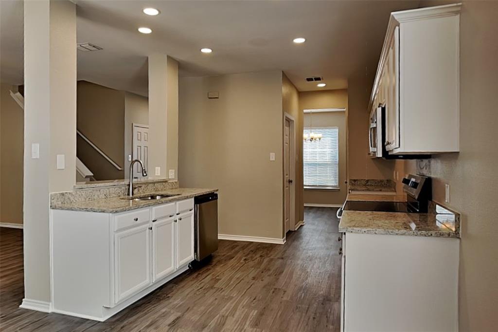 1202 Dove Brook Drive Allen, TX 75002 - Photo 4 of 23 Kitchen with white cabinets, light stone counters, recessed lighting, dark wood-type flooring, and stainless steel appliances