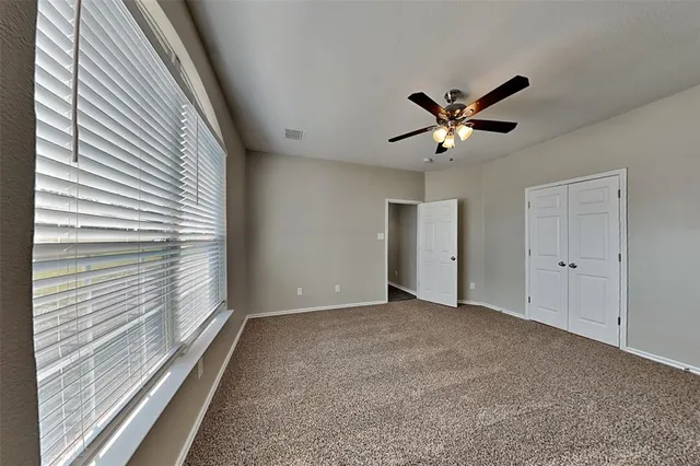 a view of a livingroom with a ceiling fan and window