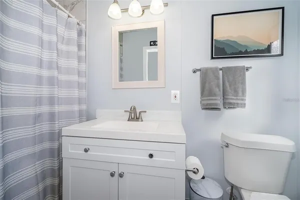 a bathroom with a toilet sink vanity and mirror