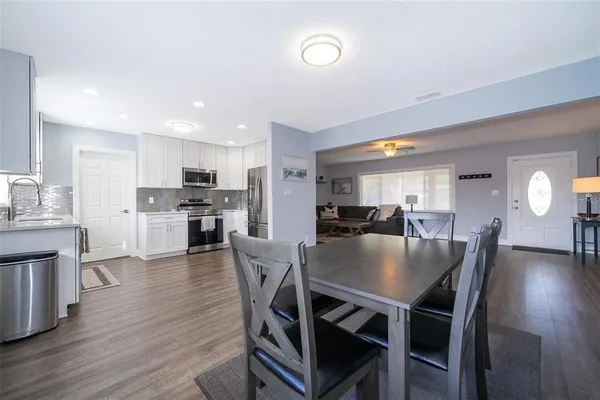 a kitchen with a dining table chairs refrigerator and cabinets