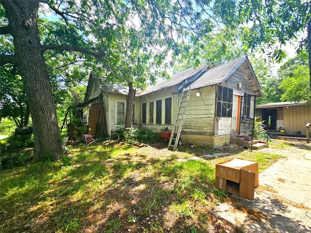 a view of a house with backyard and sitting area