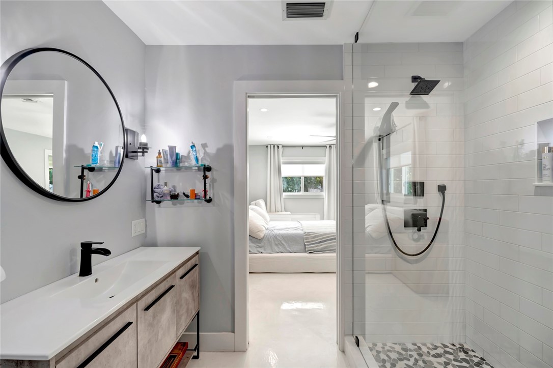 406 Indian Lilac Road Vero Beach, FL 32963 - Photo 23 of 36 a bathroom with a granite countertop sink mirror and vanity