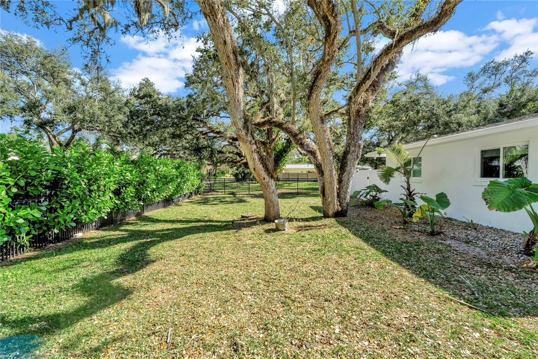 406 Indian Lilac Road Vero Beach, FL 32963 - Photo 25 of 36 a view of a backyard with large trees