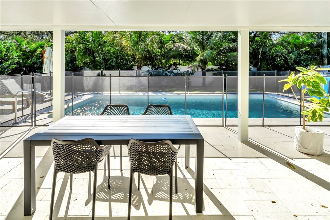406 Indian Lilac Road Vero Beach, FL 32963 - Photo 31 of 36 a view of a patio with a table and chairs